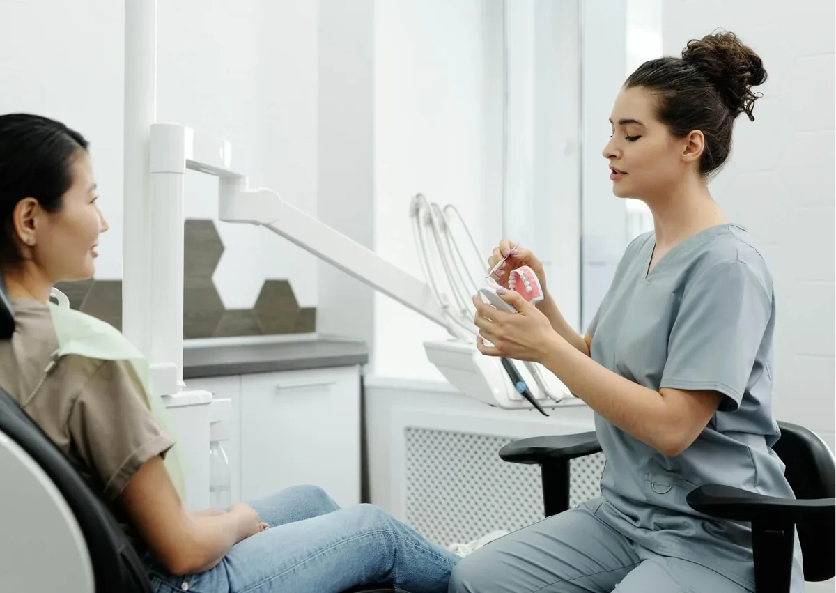 Dentist discussing smile makeover treatment options with a patient using a dental model.
