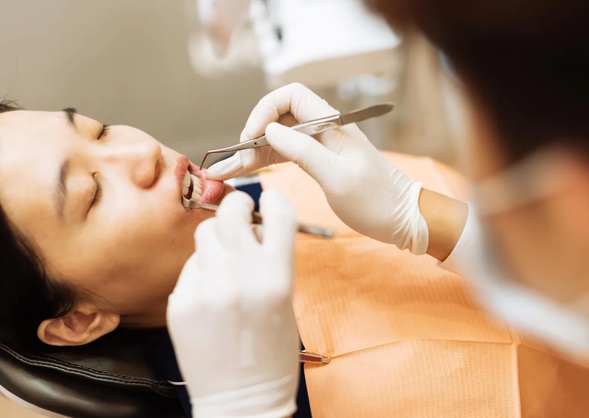 Dentist examining a patient’s gumline during an evaluation for gum contouring treatment.