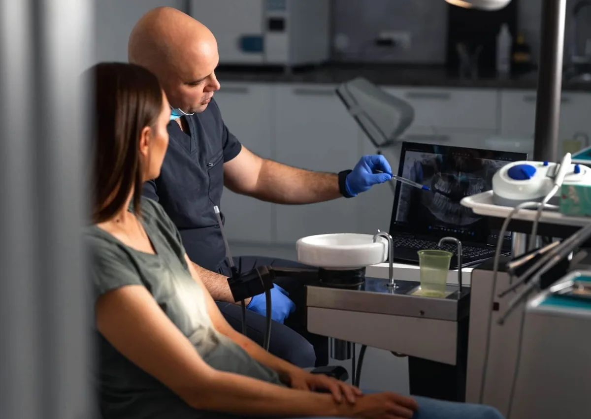 Dentist reviewing dental X-rays with a patient while discussing braces cost and orthodontic treatment options.