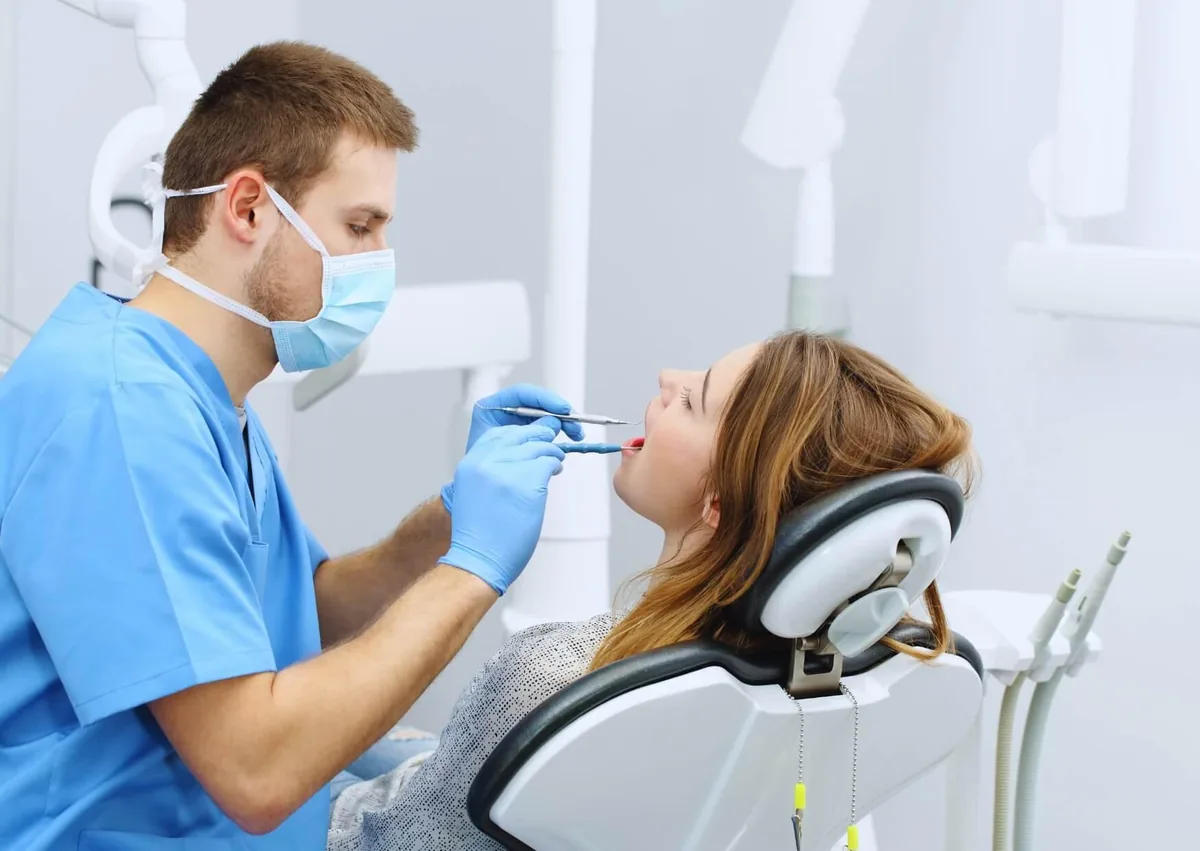 Dentist examining a patient’s teeth during a routine checkup to help prevent cavities.